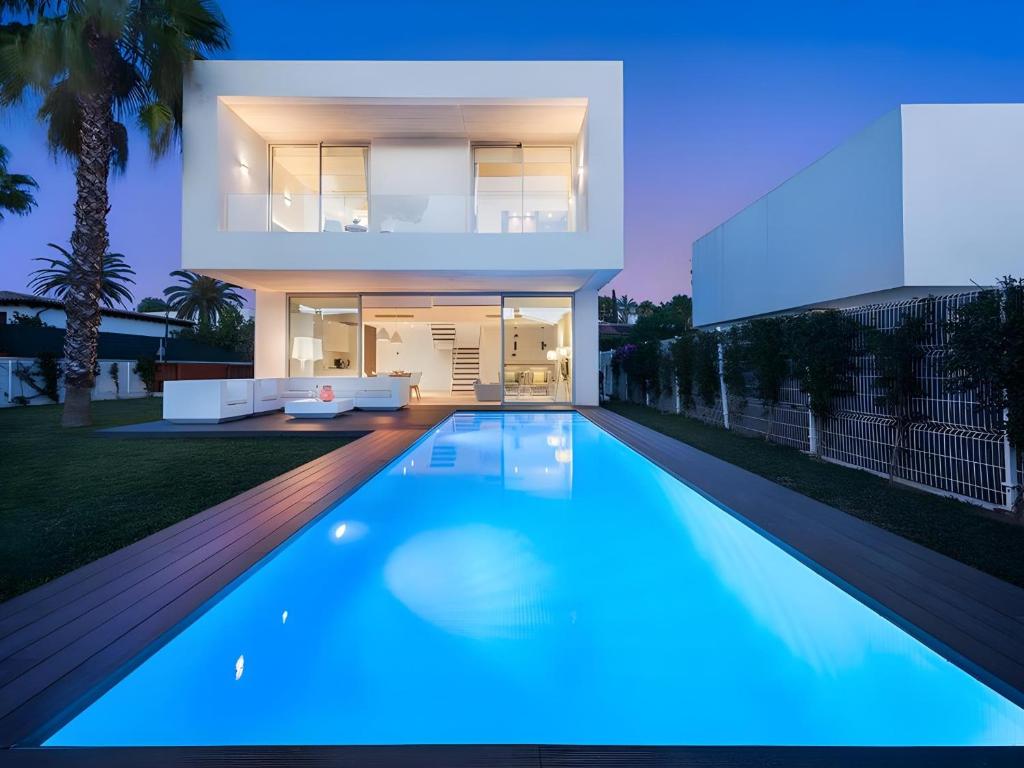 een modern huis met een zwembad in de nacht bij Villa Cuc in Playa de Muro