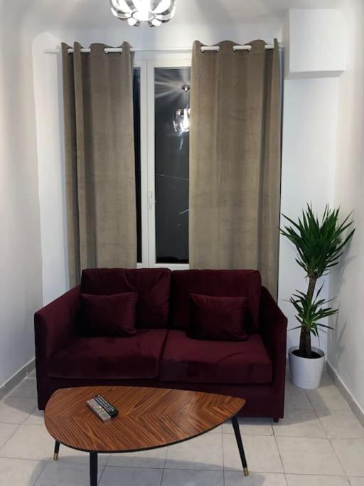 een woonkamer met een rode bank en een salontafel bij Le Bourget super appartement au centre ville in Le Bourget