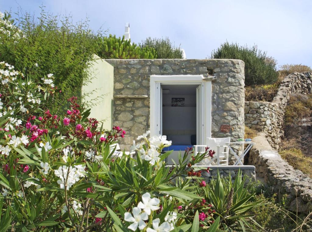 a door in a stone building with flowers at Mykonos Love Nest in Ano Mera