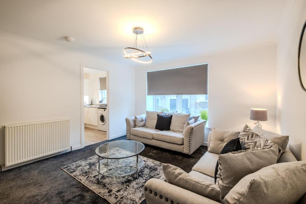 a living room with two couches and a glass table at Central City Hideaway - Luxury 2 Bed city centre Apartment in Aberdeen