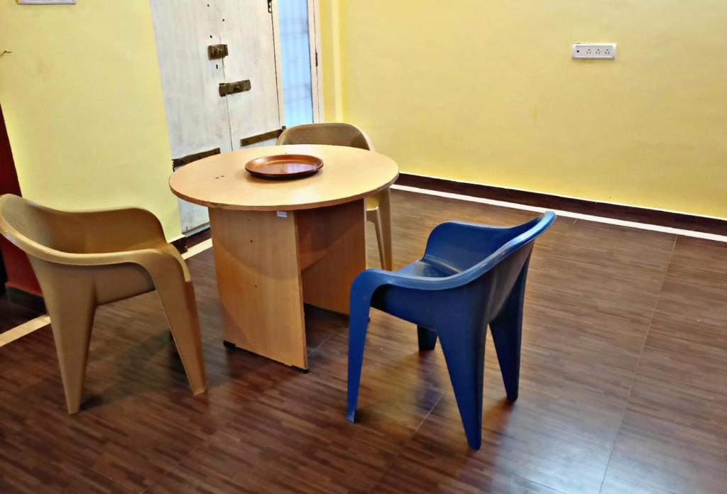 een kleine tafel en stoelen in een kamer bij Reves by Le Apex in Kottakupam