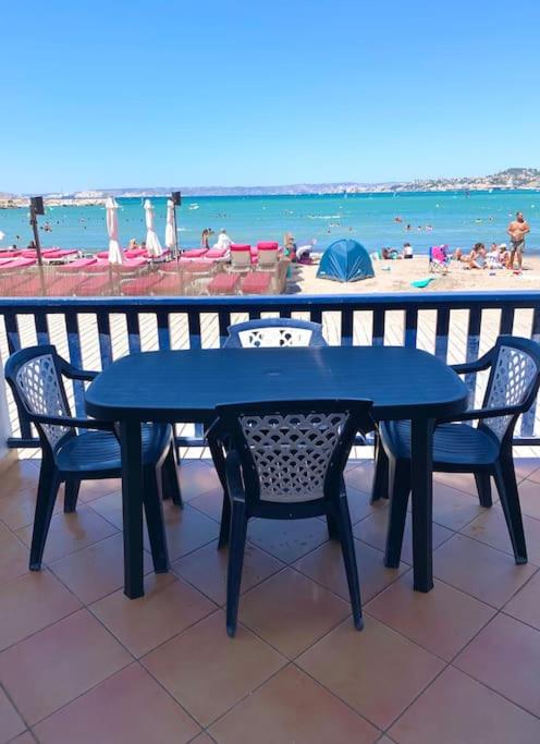 - une table bleue et des chaises avec vue sur la plage dans l'établissement Charmant cabanon les pieds dans l’eau…, à Marseille
