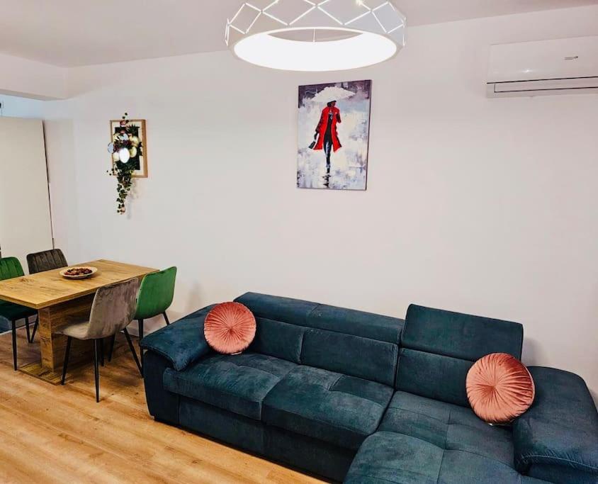 ein Wohnzimmer mit einem blauen Sofa und einem Tisch in der Unterkunft Joy City Stay Mara M10-12 in Timişoara