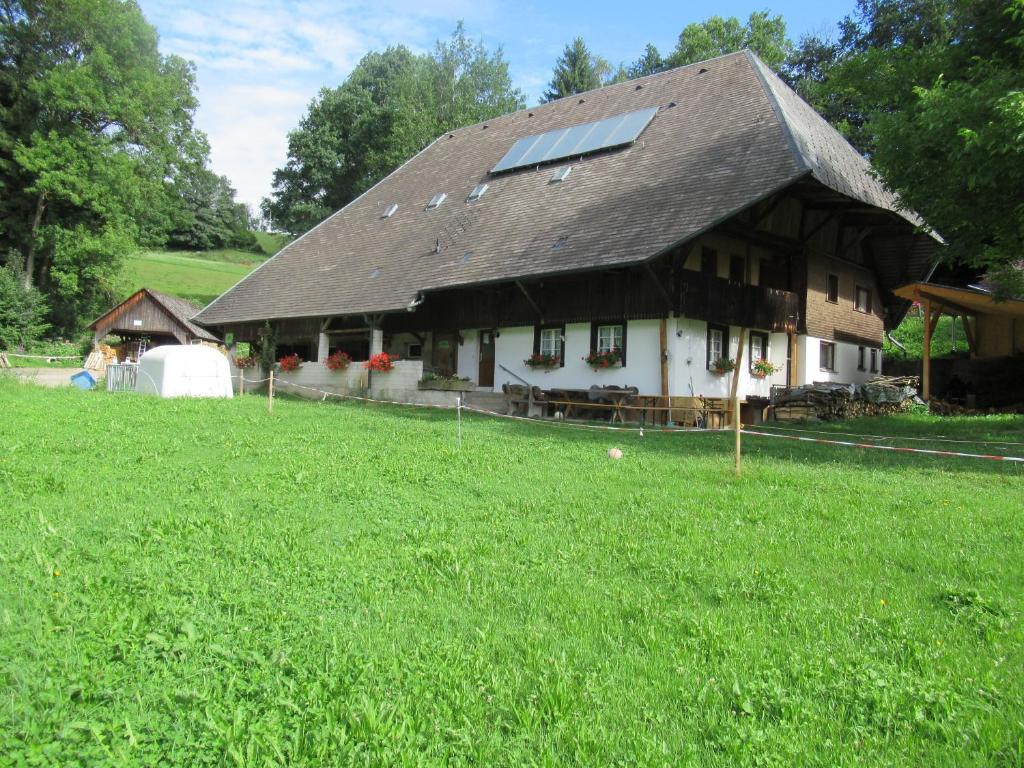 uma casa com um telhado com um grande campo de relva em Ferienhaus Pfisterhof em Kirchzarten