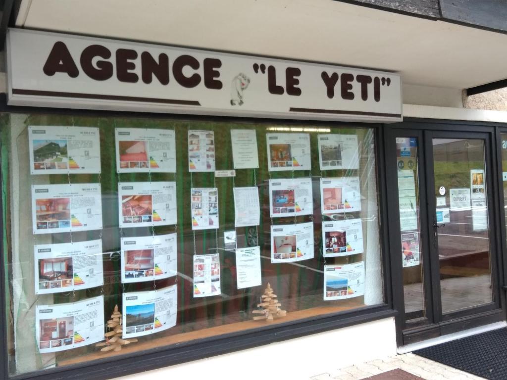 ein Schaufenster vor dem Laden mit einer Anzeige von Papieren in der Unterkunft Appartement Yeti Immobilier 2 in Thollon