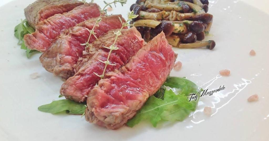 un plato blanco de comida con carne y verduras en LOCANDA TRIESTE, en Bonavigo