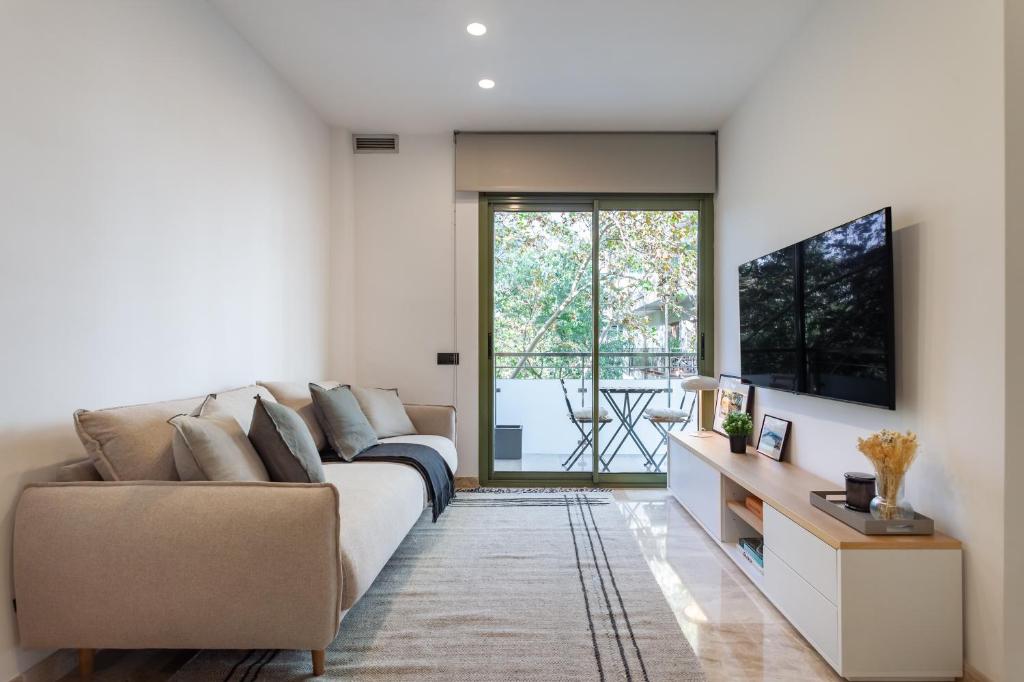 a living room with a couch and a tv at Cozy Apartment Les Corts in Barcelona