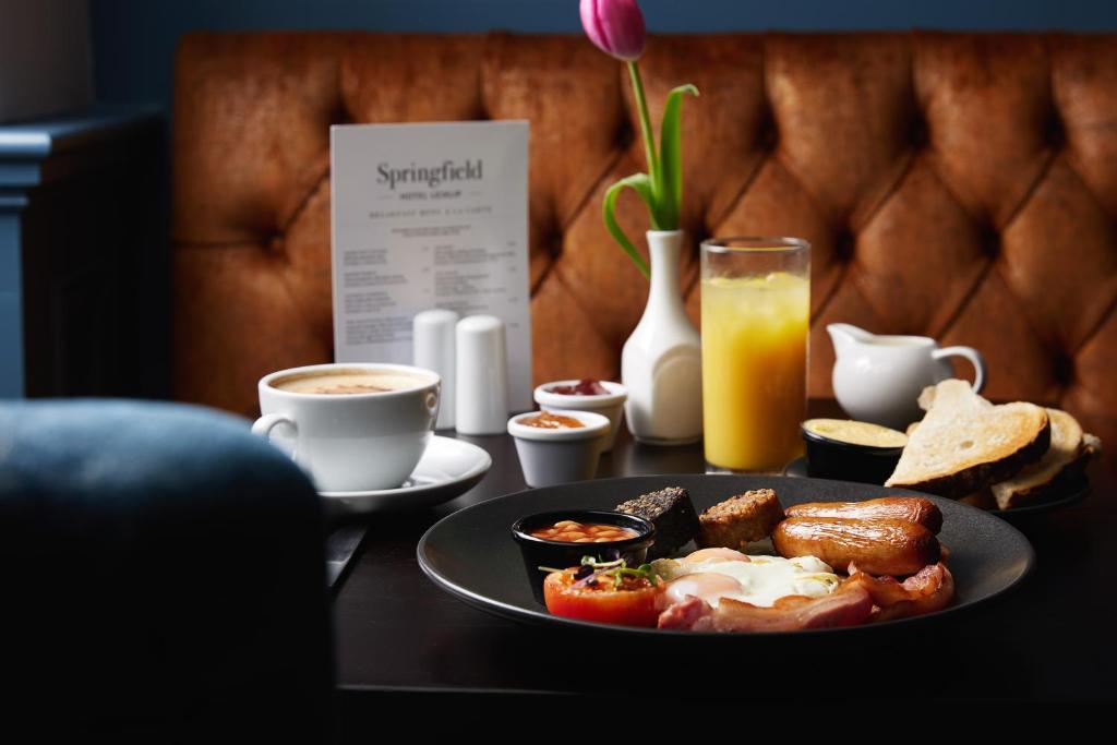 a table with a plate of breakfast food and drinks at Springfield Hotel in Leixlip
