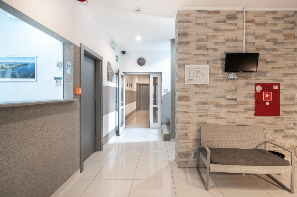 a hospital hallway with a fireplace and a tv on a wall at Keja Rooms II - Pokoje Noclegi w Centrum Gdyni in Gdynia