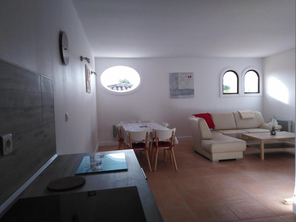 Gîte Les Songes في Canet: غرفة معيشة مع أريكة وطاولة