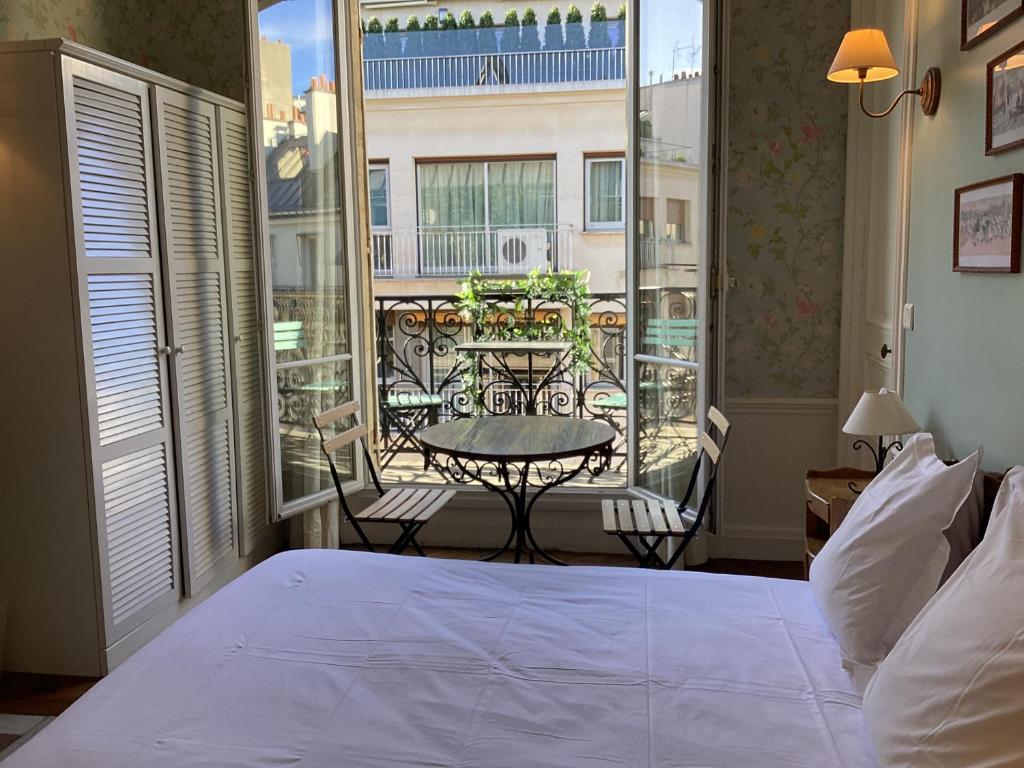 a bedroom with a bed and a balcony with a table at BED and BREAKFAST PARIS QUARTIER CHAMPS-ÉLYSÉES in Paris