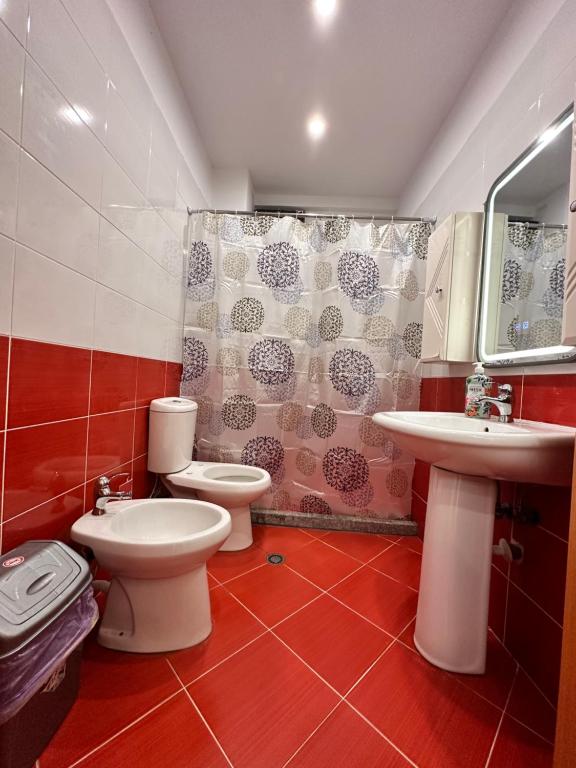 ein Badezimmer mit 2 WCs, einem Waschbecken und einer Dusche in der Unterkunft Tirana Apartment in Kashari