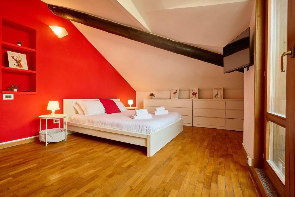a bedroom with a red wall and a bed at Moscova Charme Apartment in Milan