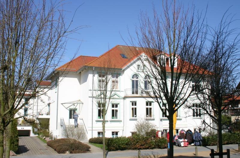 a large white house with a red roof at Apartmenthaus Strandstraße 34 in Kühlungsborn