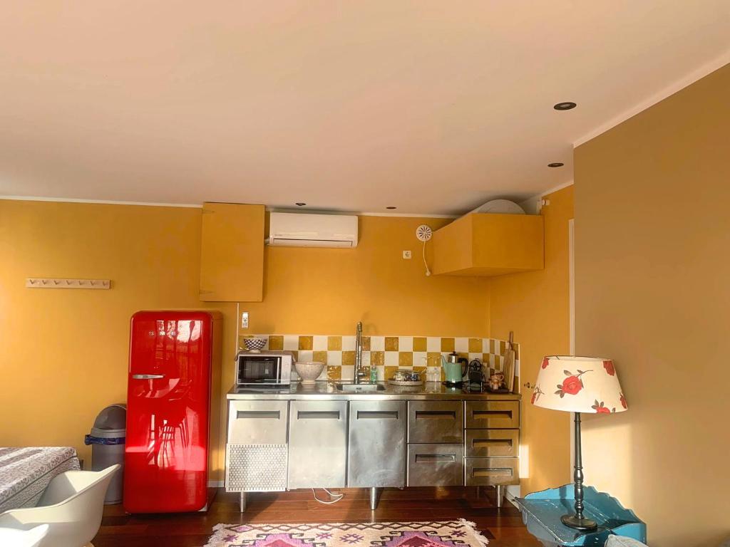 eine Küche mit einem roten Kühlschrank im Zimmer in der Unterkunft B&B NR6 in Herbaijum