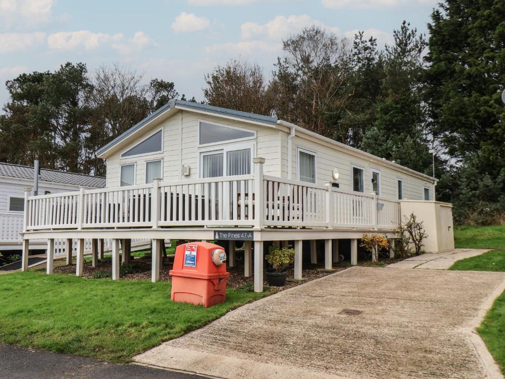 a large white house with a porch and a yard at Evergreen Pines in Scarborough