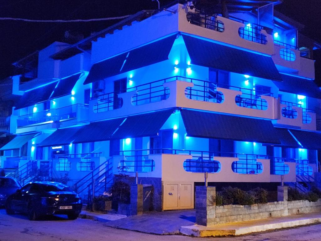 un edificio con luces azules por la noche en The Blue Beach Apartments, en Nea Peramos