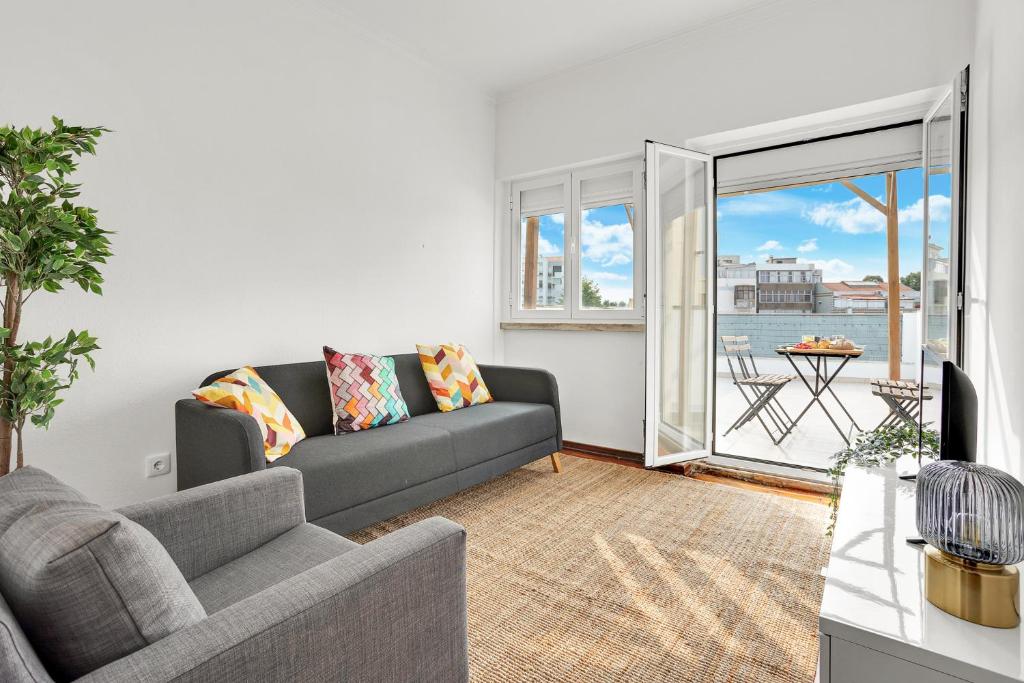 a living room with a couch and a window at Sunny Apt in Almada with Tejo View in Almada