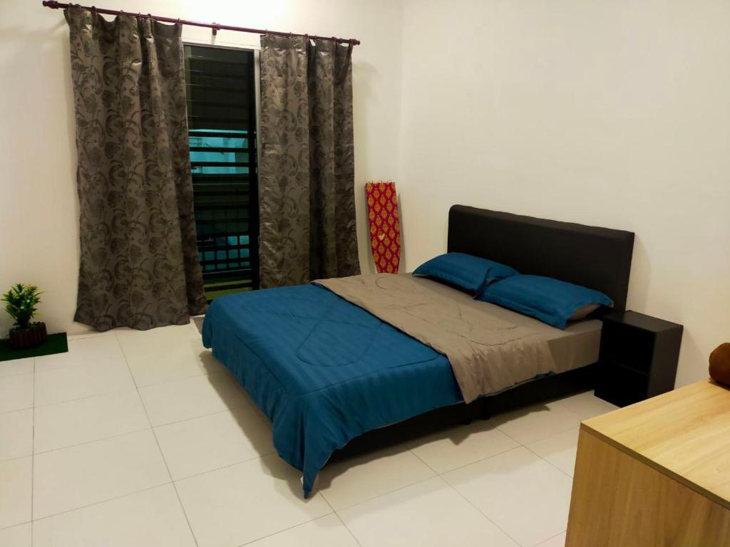 Schlafzimmer mit einem Bett mit blauer Bettwäsche und einem Fenster in der Unterkunft Homestay Manitha in Seri Manjung