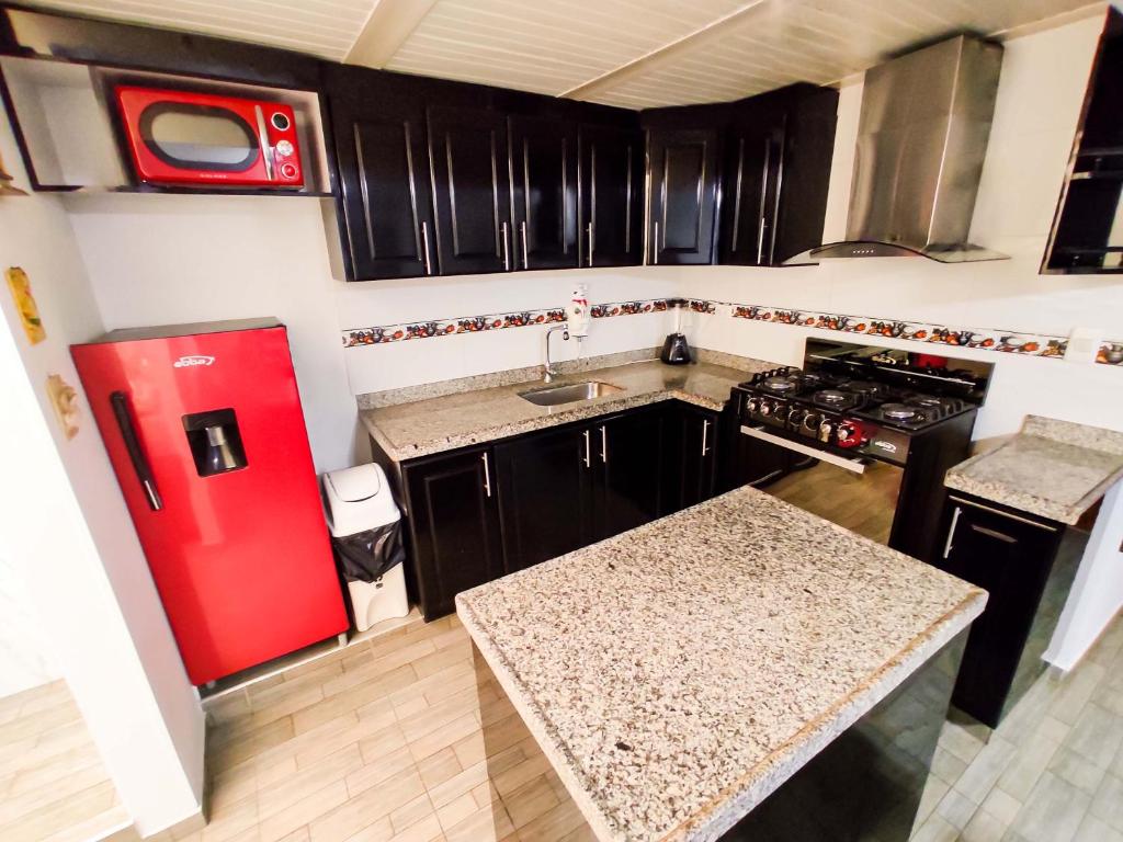 uma pequena cozinha com um frigorífico vermelho e um lavatório em Excelente Apto a 10 minutos de el Aeropuerto em Bogotá
