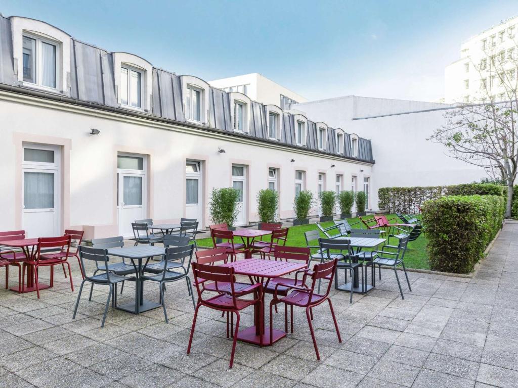 a patio with tables and chairs in front of a building at ibis Paris Gare de Lyon Ledru Rollin in Paris