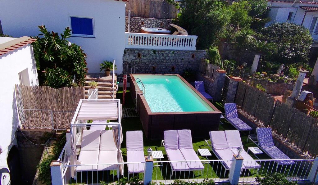 una piscina all'aperto con sedie a sdraio e una piscina di B&B La Danza del Mare ad Anacapri