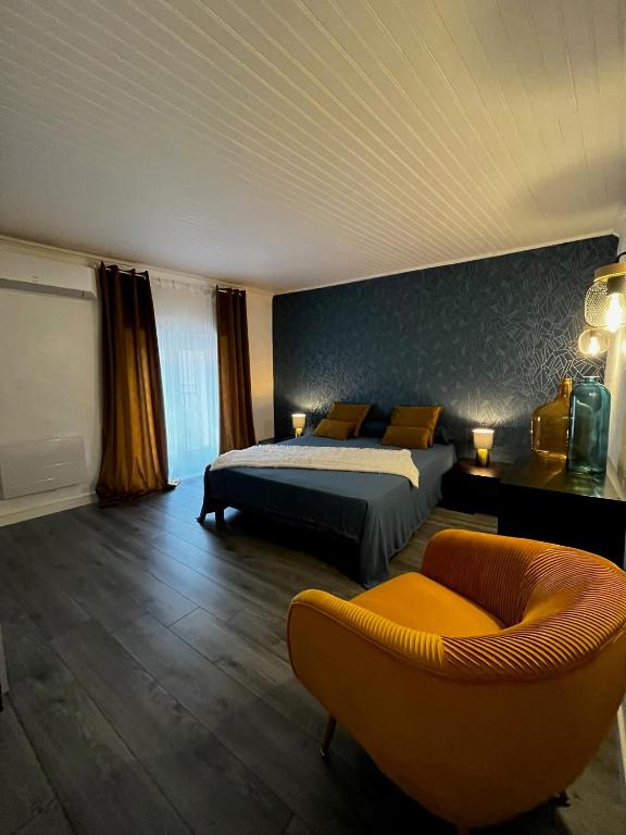 une chambre avec un lit, un canapé et une chaise dans l'établissement LE SOUSTET, à Châteauneuf-du-Pape