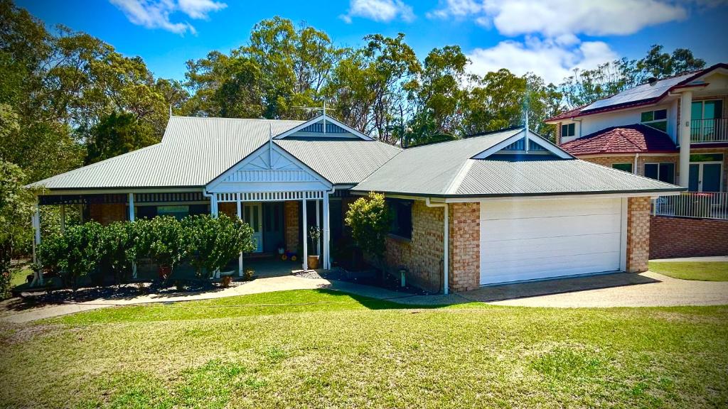 a house with a garage in a yard at Perfect North Brisbane Retreat 4 bed in Griffin