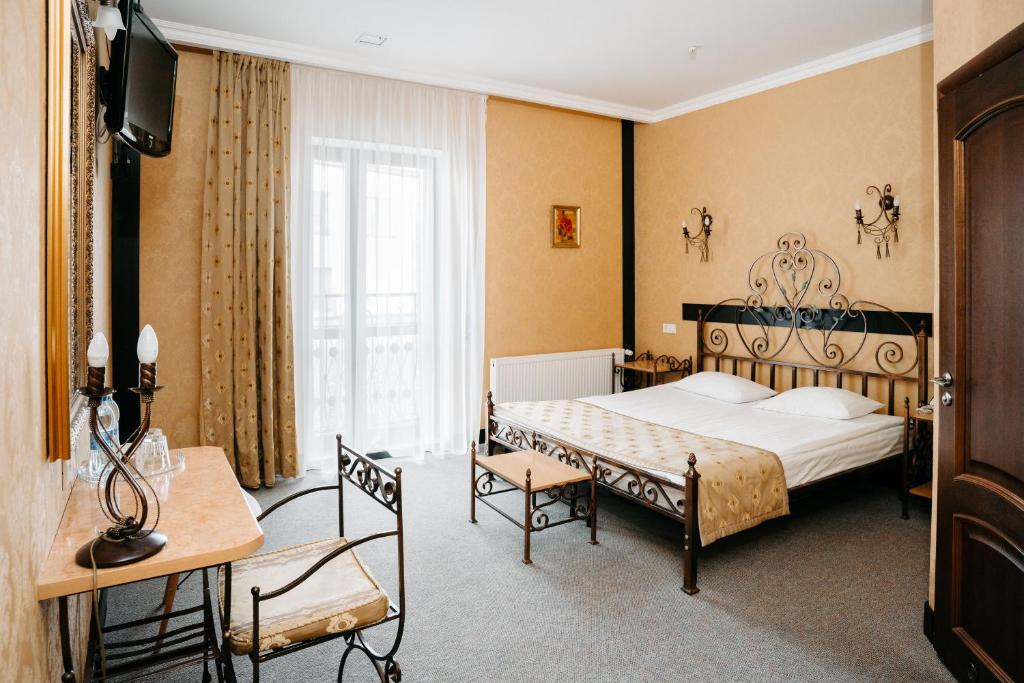 SPA-Hotel Dodo في جيتومير: غرفة نوم بسرير وتلفزيون في غرفة