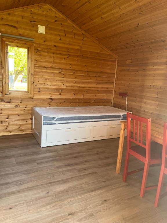 ein Schlafzimmer mit einem Bett in einer Holzhütte in der Unterkunft Frykenbadens Camping in Kil