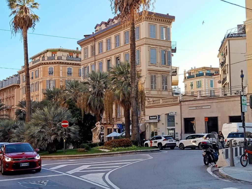 una calle con coches y un edificio con palmeras en -A Ca' Du Degre'- A un Passo da Via Matteotti, en San Remo