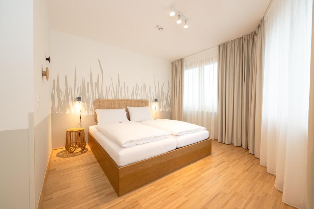 維也納的住宿－HausPension，卧室设有白色的床和大窗户