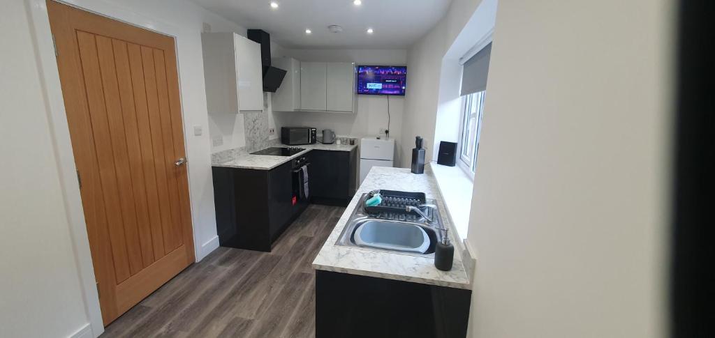 uma cozinha com um lavatório e uma bancada em Imperial Apartments. Brand New, 2 Bed In Goole. em Goole