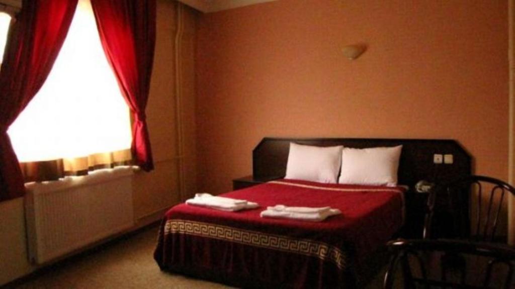 - une chambre avec un lit doté d'une couverture rouge et d'une fenêtre dans l'établissement snowrose hotel, à Şahinbey