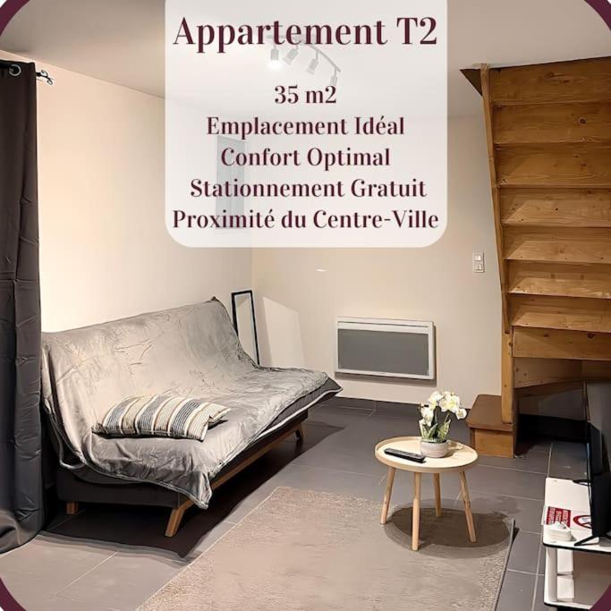 Habitación con cama y mesa. en Appartement 2 pièces RDC en duplex vue cour Parking Gratuit à 20mètres, en Roanne