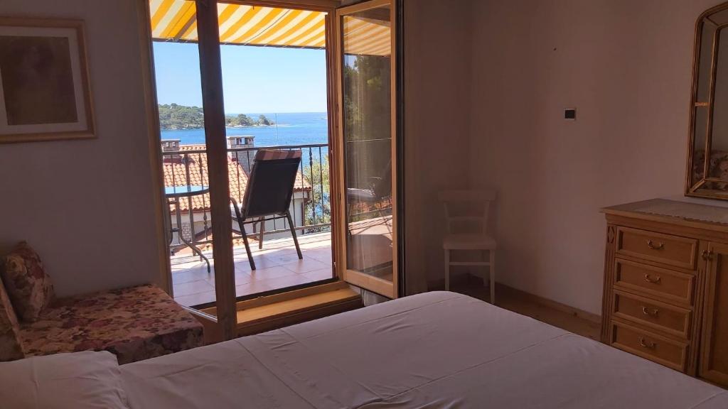 a bedroom with a bed and a view of a balcony at Apartment Maja in Mali Lošinj