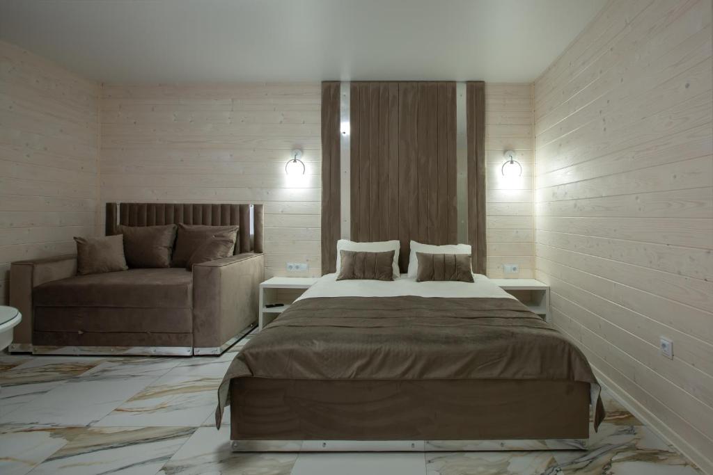una camera da letto con un letto grande e un divano di Milana SPA & Hotel - SPA included a Bukovel