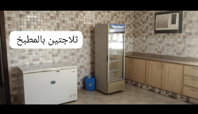 a kitchen with a refrigerator freezer in a kitchen at The Holiday Farm in Barka