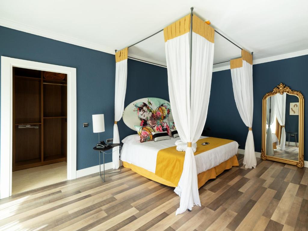 a bedroom with blue walls and a bed with a mirror at Hotel Altos de Istán in Istán