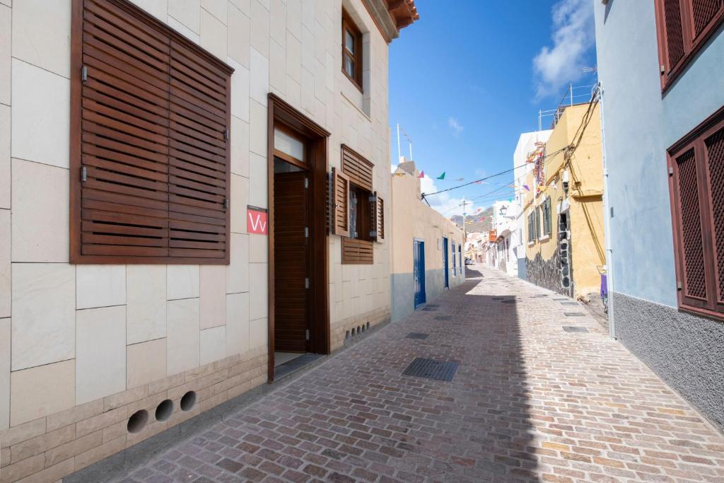 eine schmale Gasse mit blauen und weißen Gebäuden in der Unterkunft Hauzify I Apartamento Celeste in San Sebastián de la Gomera