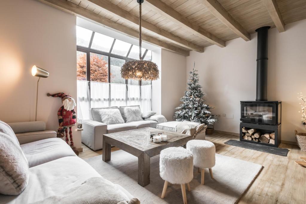 uma sala cheia de móveis e uma árvore de Natal em Casa Baqueira em Betrén