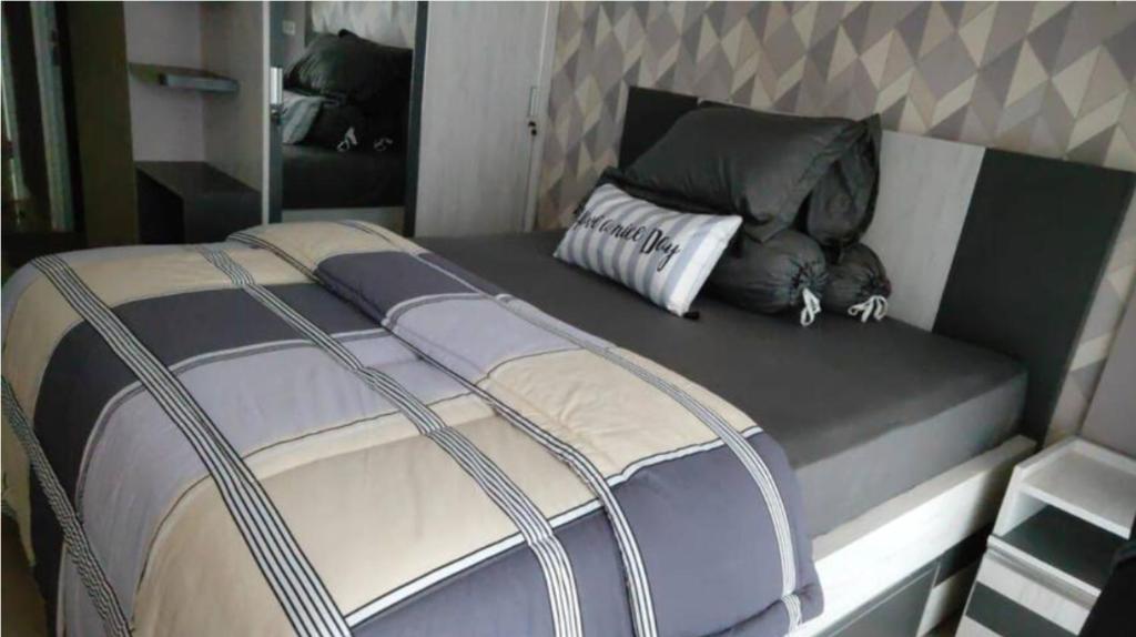 Bett in einem Zimmer mit Kissen darauf in der Unterkunft Apartemen Skylounge Makassar in Manda
