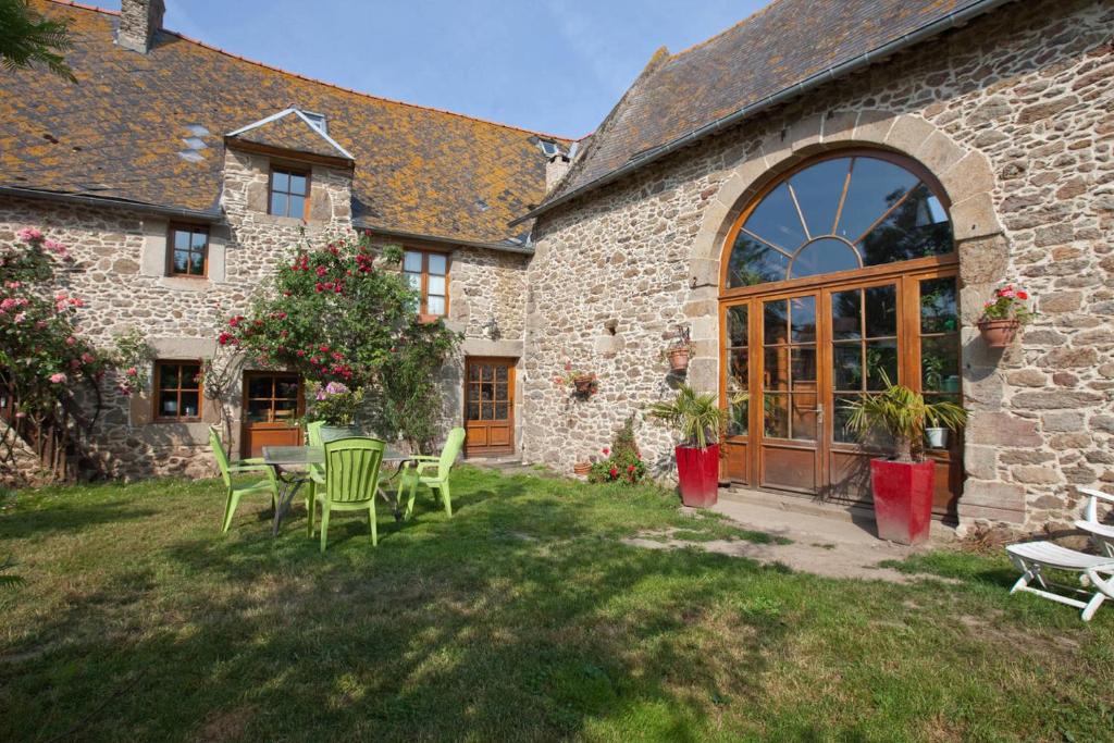 a stone building with a table and chairs in the yard at Chambres d'Hôtes du Manoir du Haut Salmon in Saint Malo