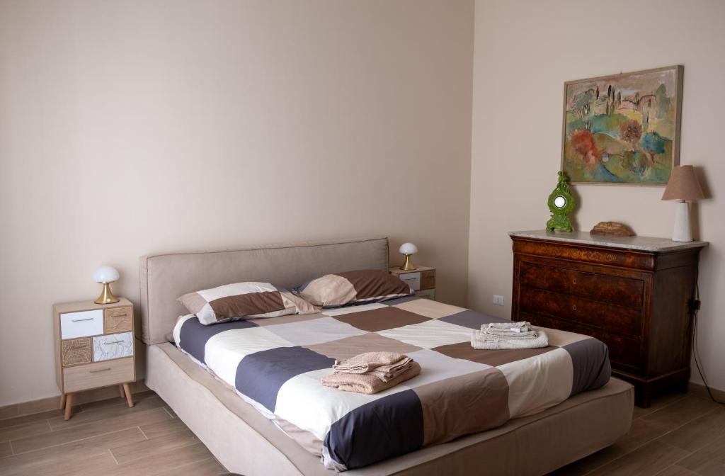 a bedroom with a large bed and a dresser at CASA MIRELLA in Casale Monferrato