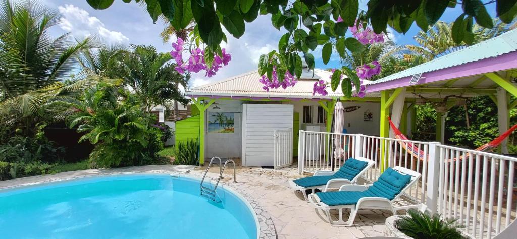 a house with a swimming pool and two chairs at Logisrev in Sainte-Anne