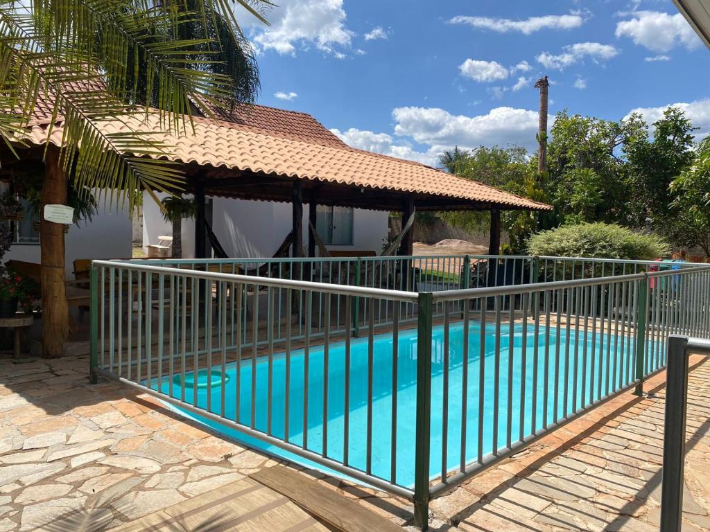 a fence around a swimming pool with a gazebo at Pousada Mirante da Lua in Alto Paraíso de Goiás