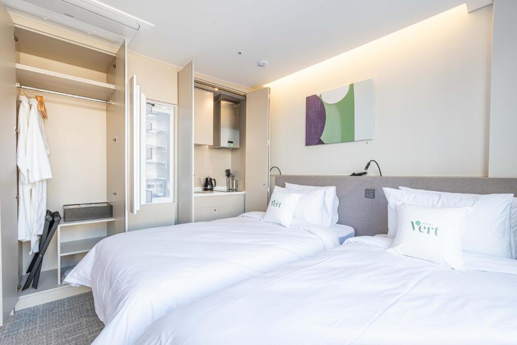 2 camas en un dormitorio con sábanas blancas en Hotel Vert en Seúl