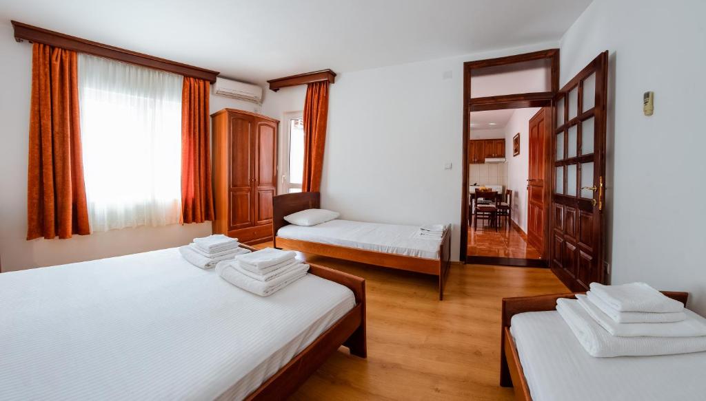 ブドヴァにあるVilla MDのベッド2台とリビングルームが備わる客室です。