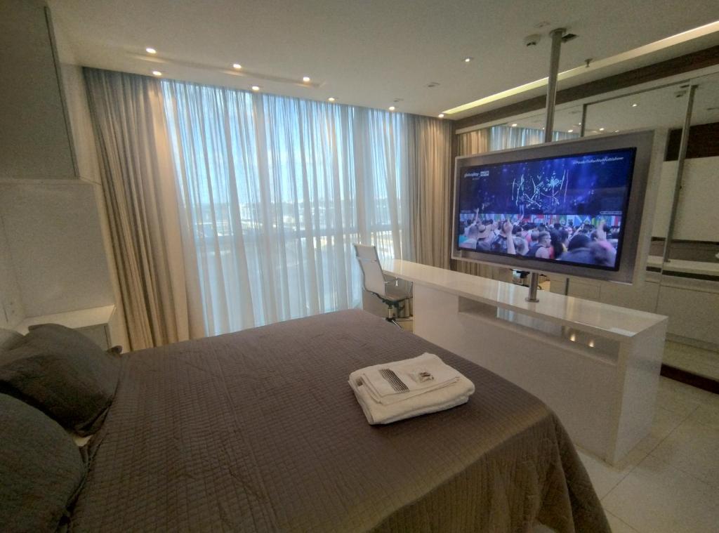 um quarto com uma cama e uma televisão de ecrã plano em Jade Hotel BLUE Tree Brasília Flat Particular wi-fi e garagem grátis sem café em Brasília