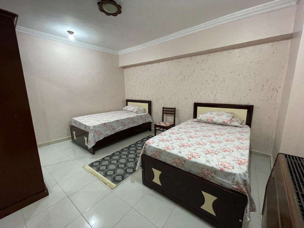 a bedroom with two beds in a room at Dr milad shokralla multiple central flats in Luxor